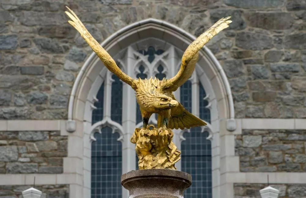 A golden eagle on a pedestal in front of a building on Boston College's campus.