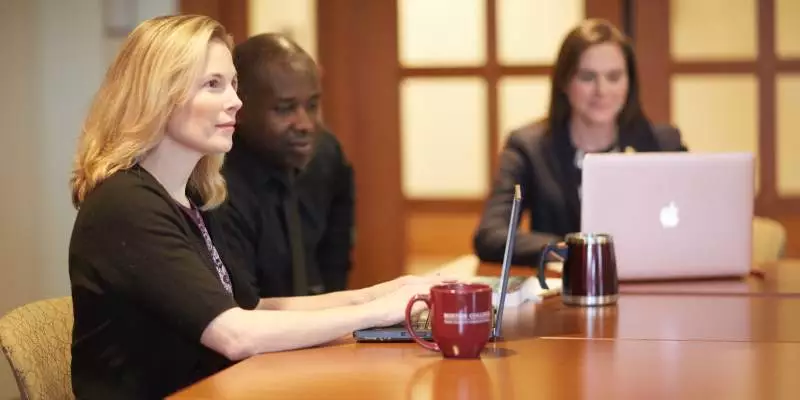 Healthcare administrators gather around a conference table.