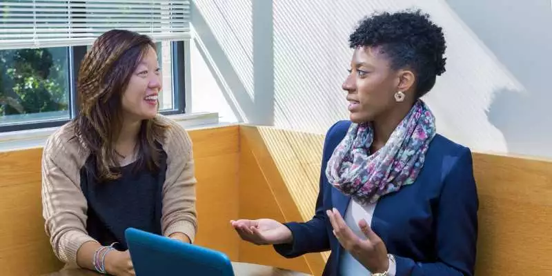 An executive coach speaks to a student.