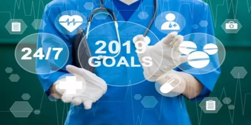 A healthcare professional touches a transparent screen filled with circles, the most prominent circle containing the words "2019 Goals."