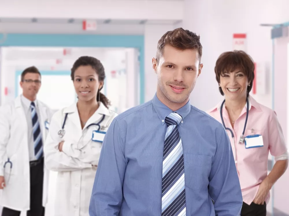 Four healthcare professionals smile at the camera.